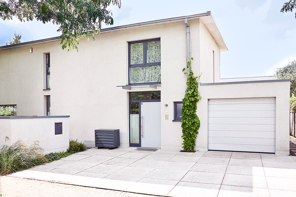 modernes Haus mit Garage und Klimaanlage davor