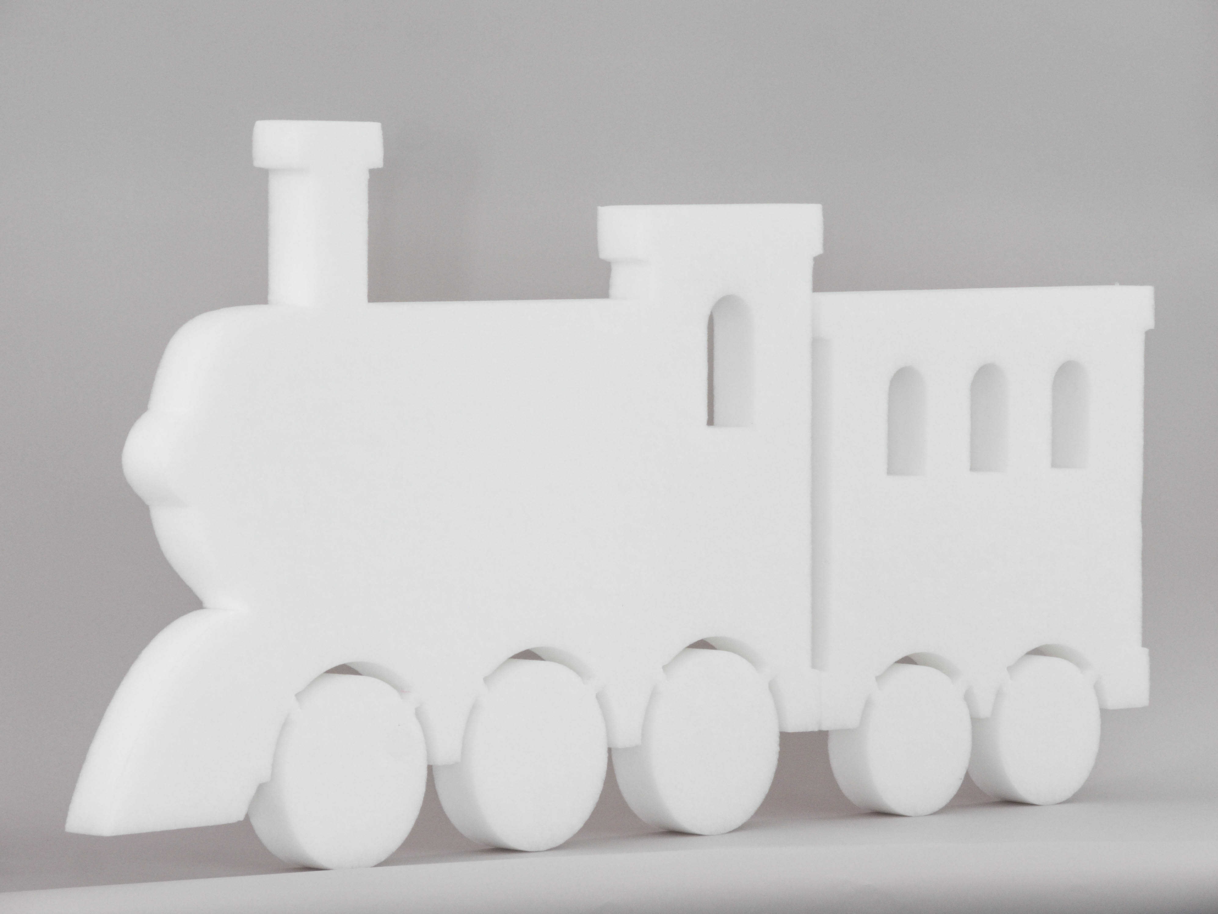 Sound absorber in the form of a locomotive and a wagon (soni ELEMENT TRAIN) in the color white photographed diagonally against a gray background