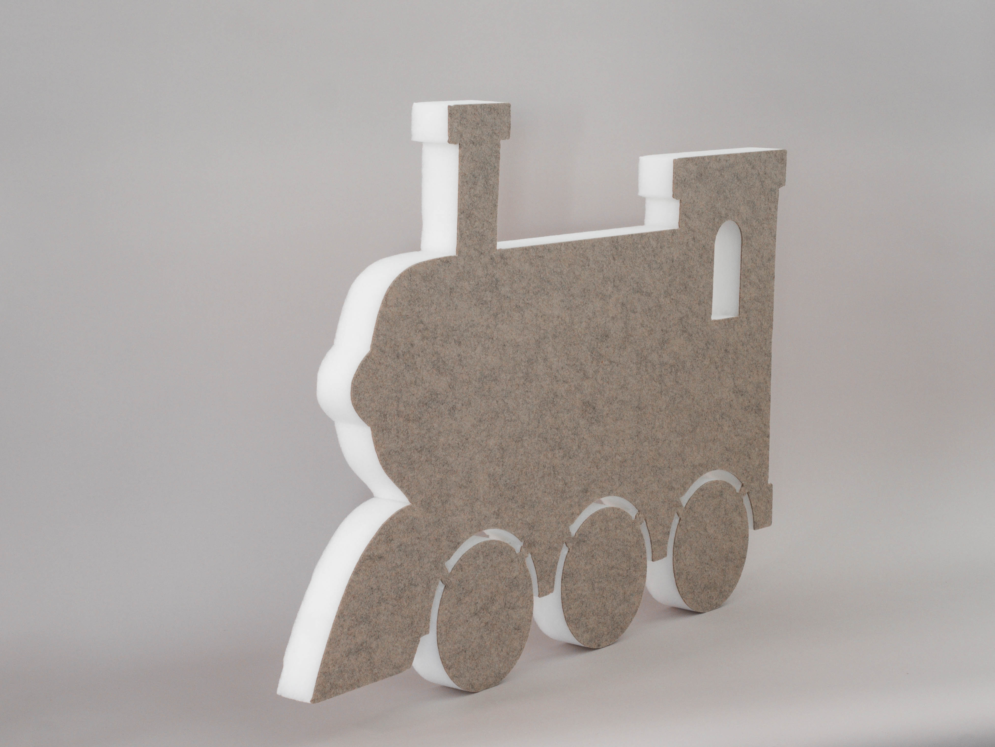 Schallabsorber in Form einer Lokomotive (soni ELEMENT TRAIN) in der Farbe Beige vor grauem Hintergrund diagonal fotografiert