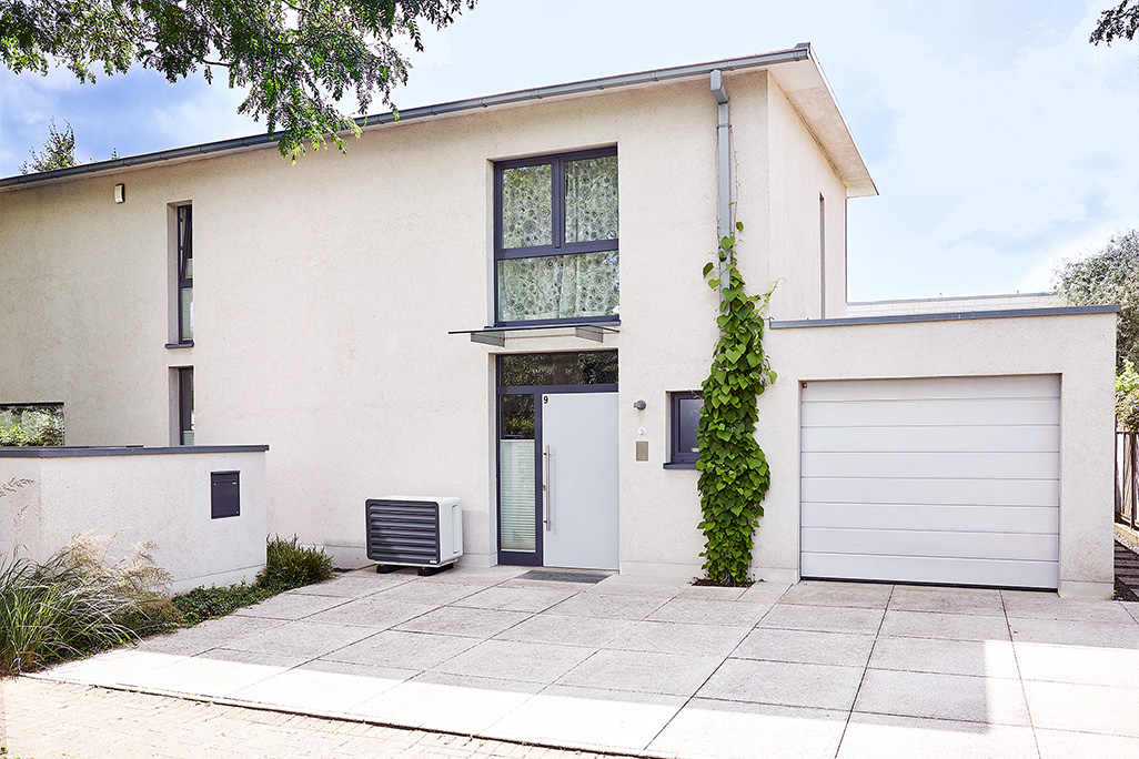 modernes Haus mit Garage und Klimaanlage davor