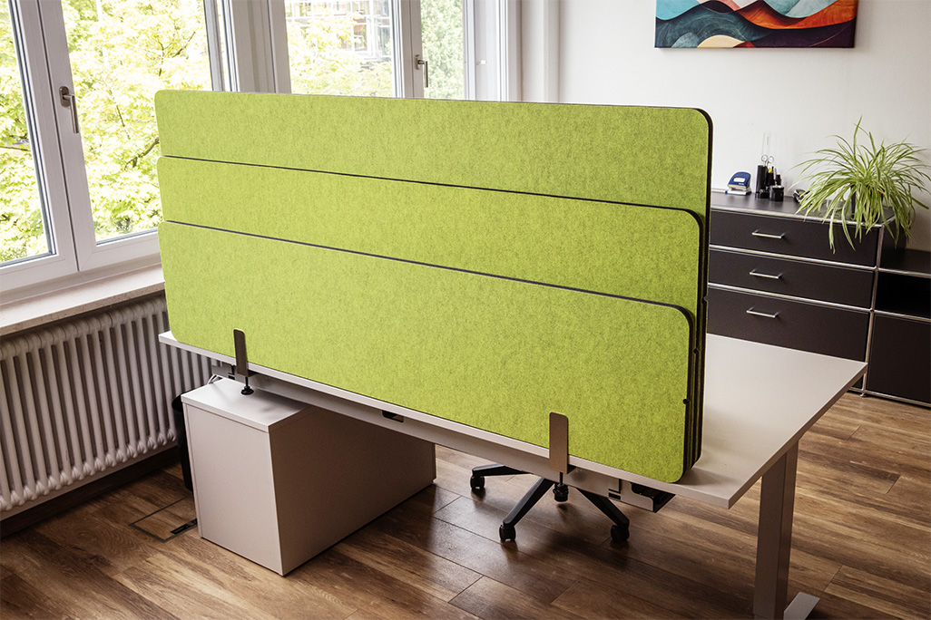 Grüne Tischtrennwand in einem Büro auf dem Schreibtisch montiert