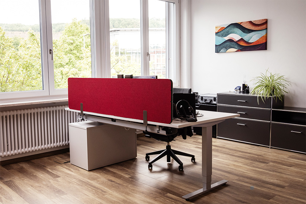 Rote Tischtrennwand in einem Büro auf dem Schreibtisch montiert