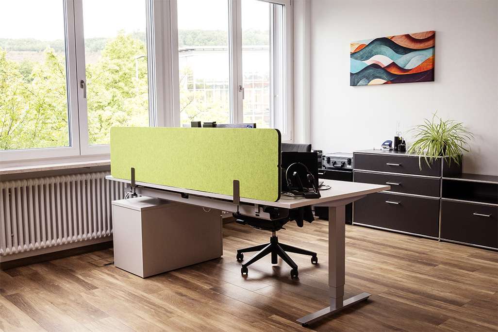 Grüne Tischtrennwand in einem Büro auf dem Schreibtisch montiert