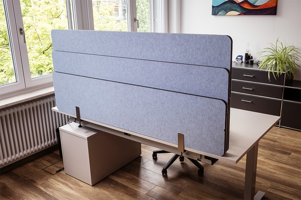 Blaue Tischtrennwand in einem Büro auf dem Schreibtisch montiert