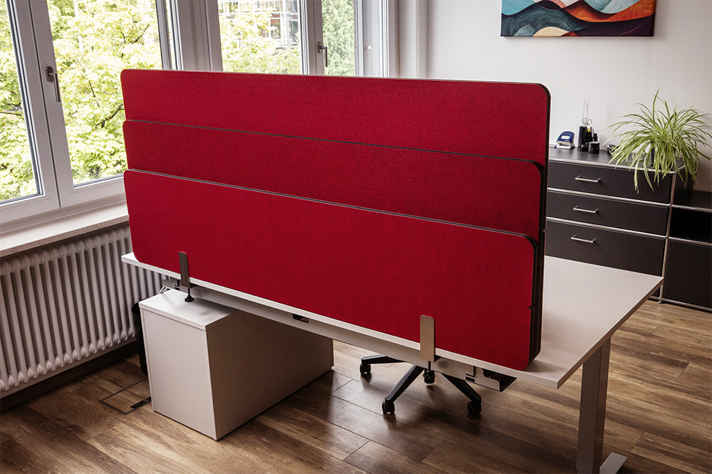 Rote Tischtrennwand in einem Büro auf dem Schreibtisch montiert