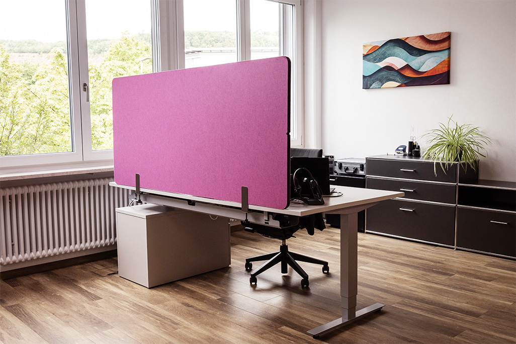 Pinke Tischtrennwand in einem Büro auf dem Schreibtisch montiert
