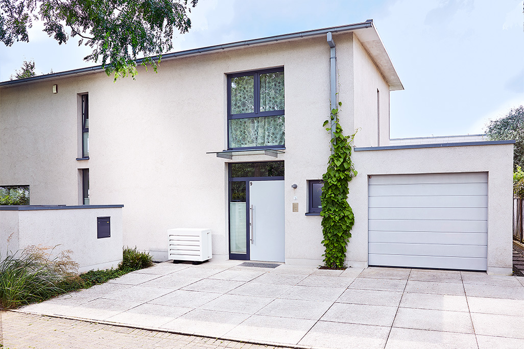 modernes Haus mit Garage und Klimaanlage davor