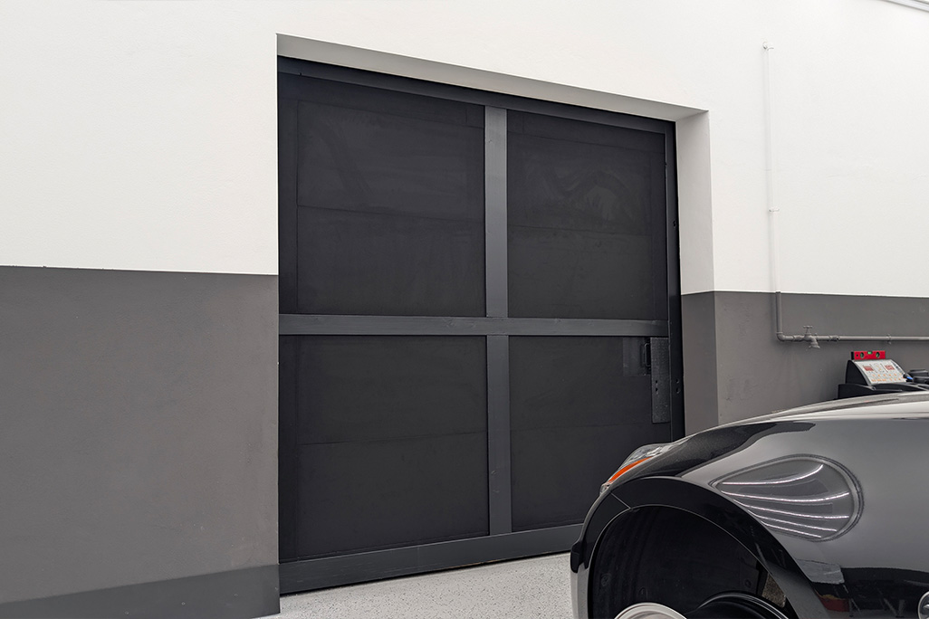 schwarze Schaumstoffplatten verkleiden eine Schiebetür einer Werkstatt