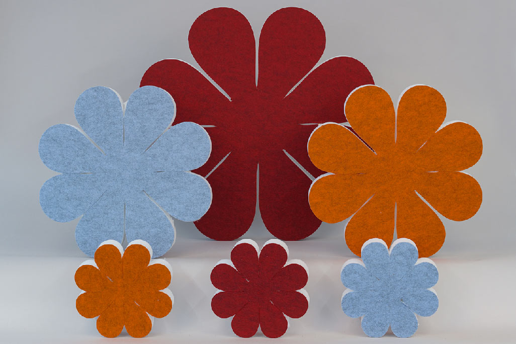 Schallabsorber in Form von großen und kleinen Blumen (soni ELEMENT FLORA) in den Favben Rot, Blau und Orange vor grauem Hintergrund