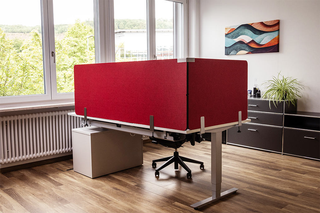 Rote Tischtrennwand in einem Büro auf dem Schreibtisch montiert