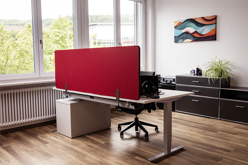 Rote Tischtrennwand in einem Büro auf dem Schreibtisch montiert