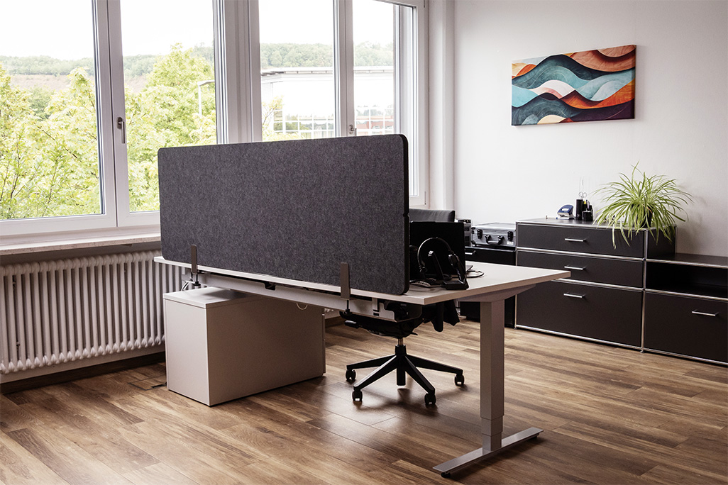 Anthrazite Tischtrennwand in einem Büro auf dem Schreibtisch montiert