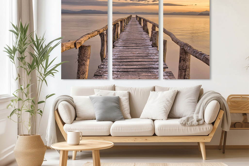 Heller freundlicher Wohnraum mit einem hellen Sofa mit beigen Polstern, dahinter an der Wand ist ein 3er Set unseres Akustikbildes soni PICTURE angebracht.