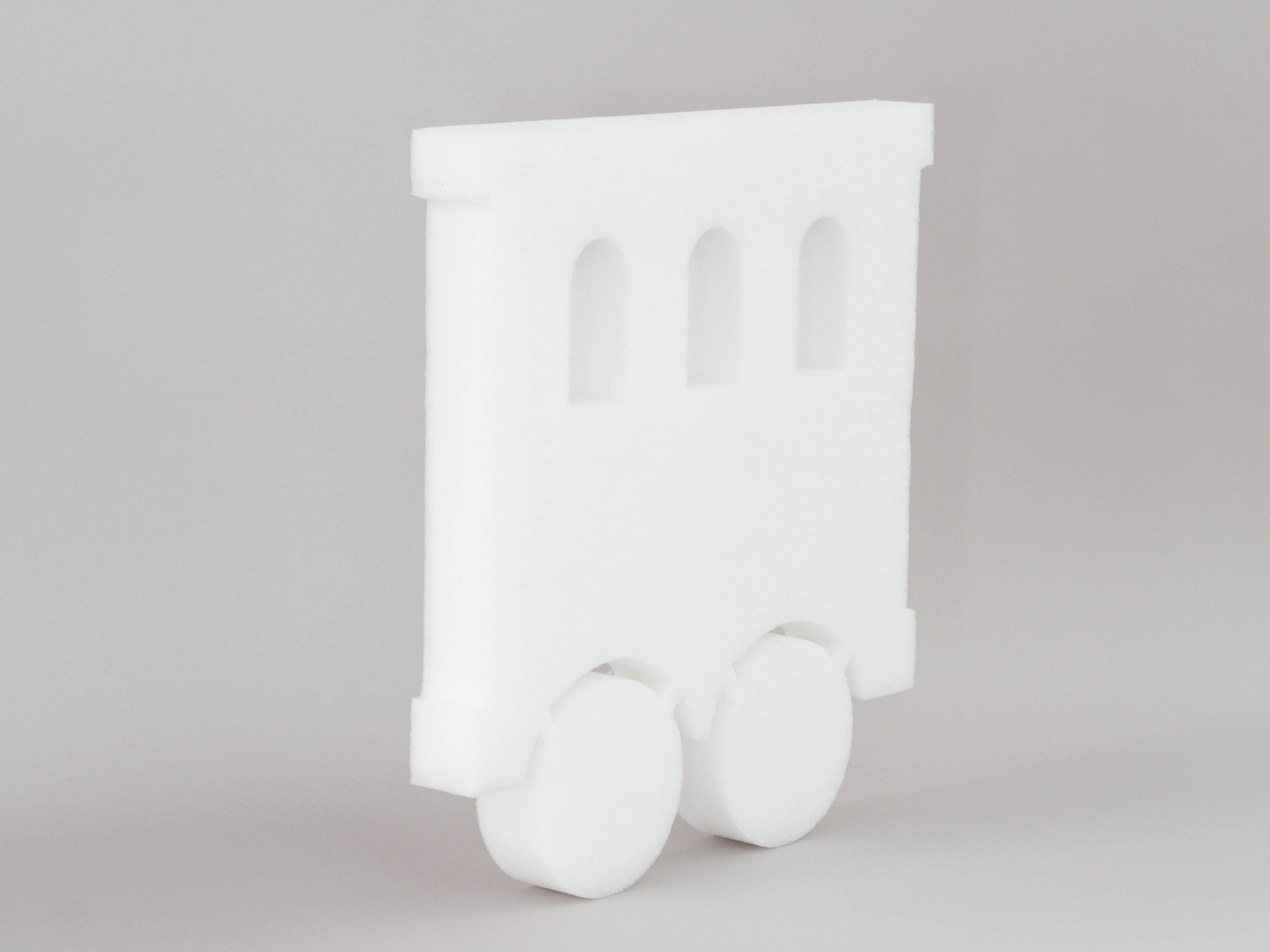 Sound absorber in the shape of a wagon (soni ELEMENT TRAIN) in white photographed diagonally against a gray background