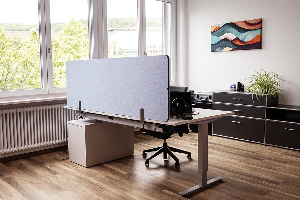 Blaue Tischtrennwand in einem Büro auf dem Schreibtisch montiert