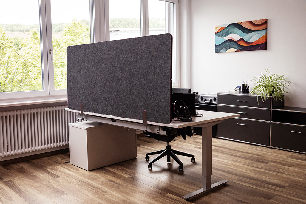Anthrazite Tischtrennwand in einem Büro auf dem Schreibtisch montiert